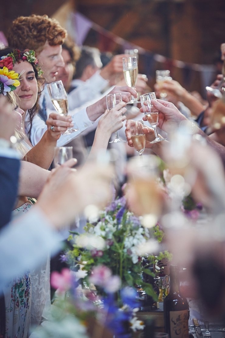 guests clinking glasses after the speeches at a boho wedding in Dorset uk