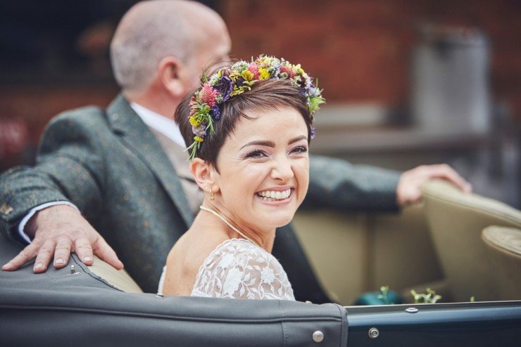 bride Megan smiling in vintage wedding car just before her hand tying ceremony at West Town Farm in Exeter