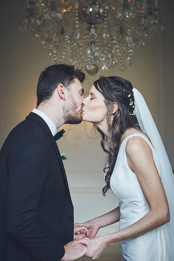 bride and groom first kiss at small wedding at Rockbeare manor in Devon