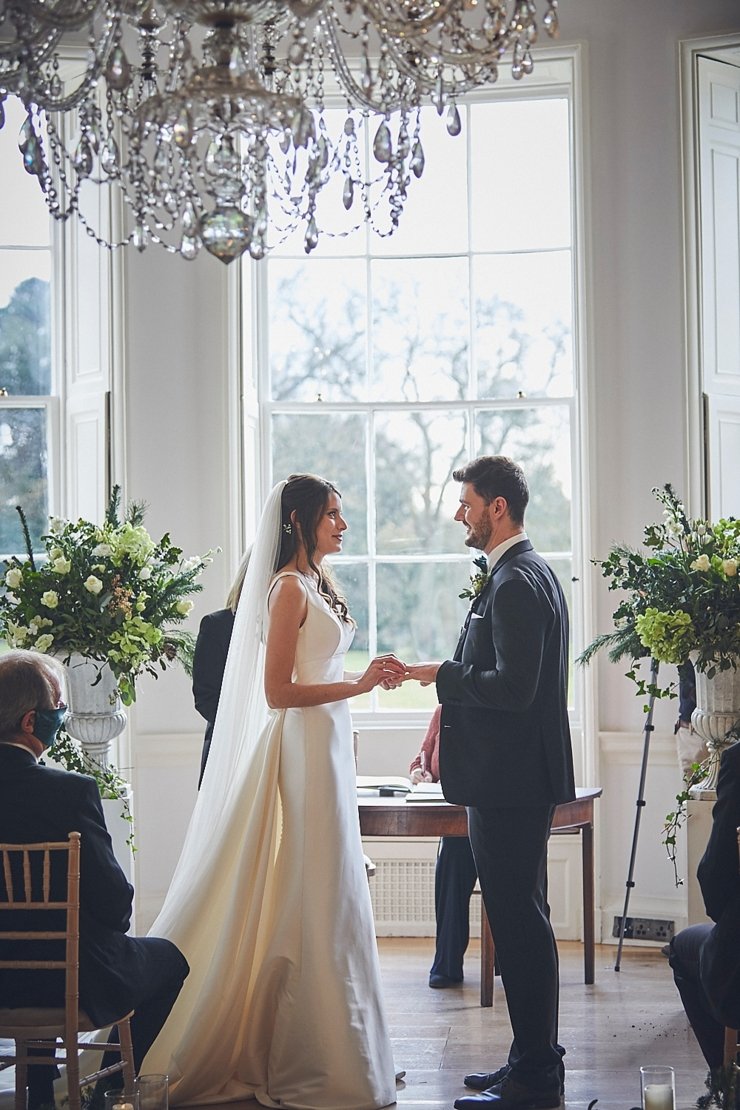 bride and groom exchanging rings at small wedding at Rockbeare manor in Devon