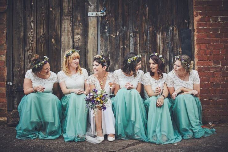 bridesmaids and bride sat together laughing at a Devon wedding at West Town farm