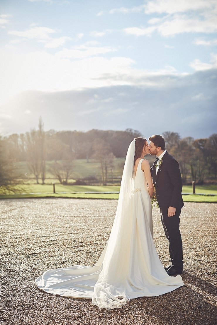 portrait of bride and groom kissing at small winter wedding at Rockbeare manor in Devon