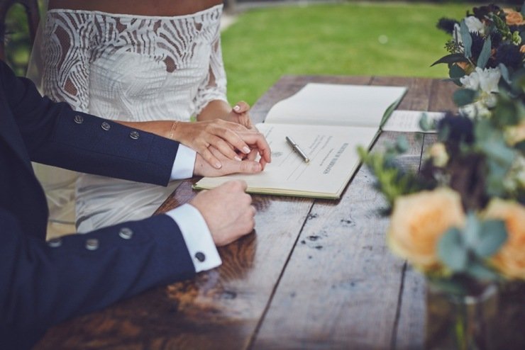 candid wedding photography of signing the register Kingston Estate Devon