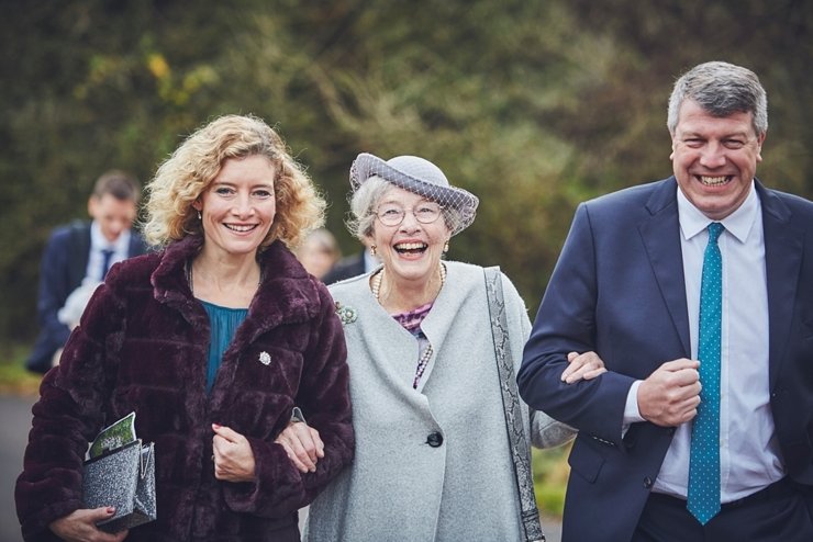 relaxed photography of happy guests walking to wedding venue at huntsham court