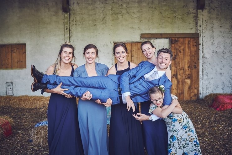 groom being held by the bridesmaids at relaxed festival eco wedding in devon