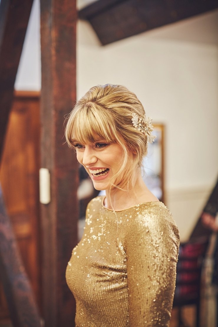 bride dressed in her gold sequinned figure hugging wedding dress laughing at a winter wedding at Huntsham Court in devon