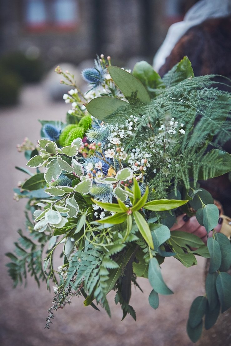 bridal bouquet for winter wedding with blue thistle, holly leaves, fern, rosemary