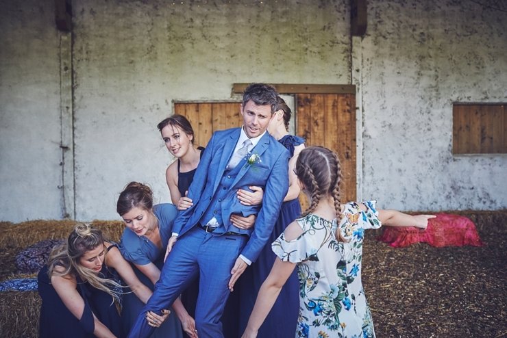relaxed wedding photography of groom being picked up by the girls at an eco wedding in devon