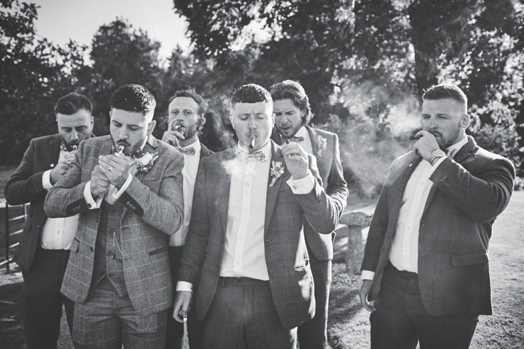 groom and ushers smiling cigars at Upton Barn and walled garden Devon