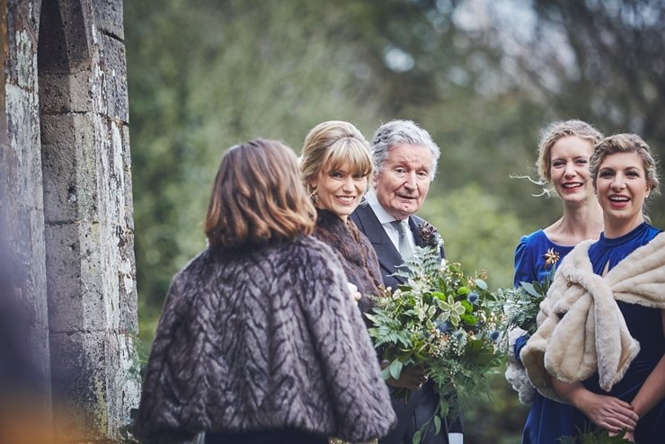 bride and groom and bridesmaids walk to the ceremony in welly boots at Huntsham Court Devon