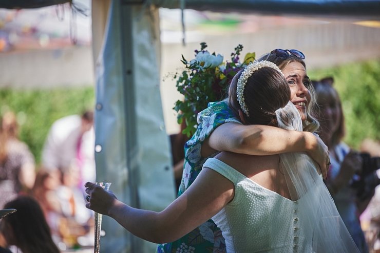 emotional guest hugging bride at festival wedding in Devon