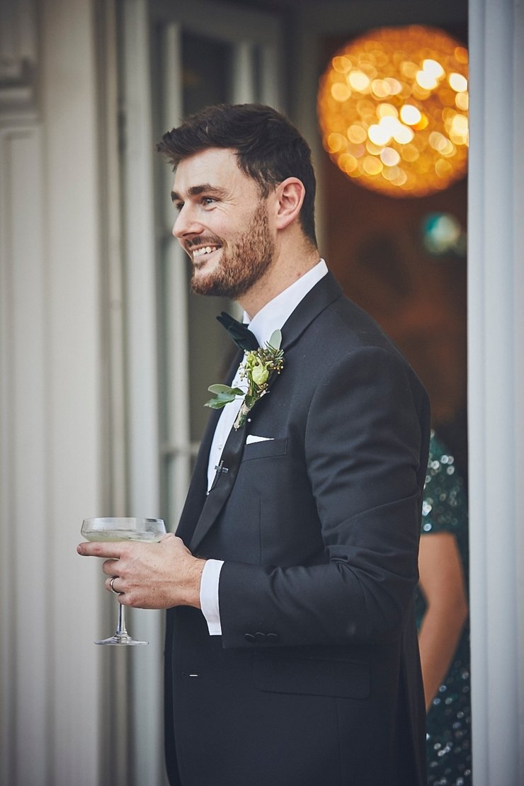 relaxed wedding photography and happy groom wearing black tie at mini wedding in Devon
