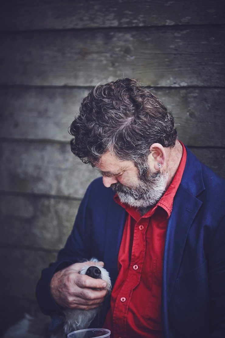 cute pic of a wedding guest holding his dogs head at rustic barn wedding in devon